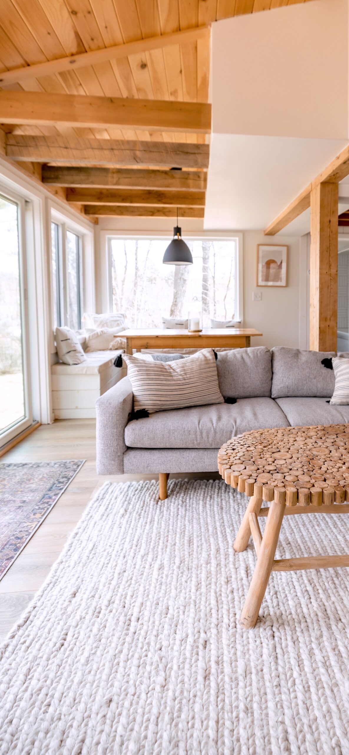 Lichte woonkamer met houten balken en grijze bank — styling en interieuradvies Friesland